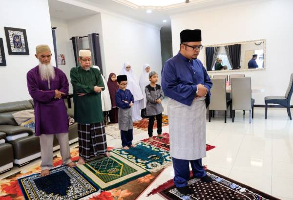 Syed Mohd Muzzaffar Syed Azlan (kanan) mengimamkan solat sunat Aidilfitri di rumahnya di Klebang Restu hari ini. -Foto Bernama