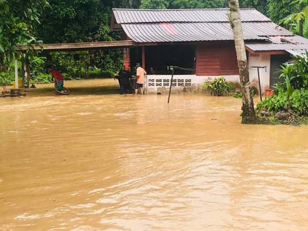 Salah sebuah rumah di Kampung Poh, di sini, dinaiki air dalam kejadian banjir kilat yang berlaku pagi tadi. - Foto: JBPM Perak