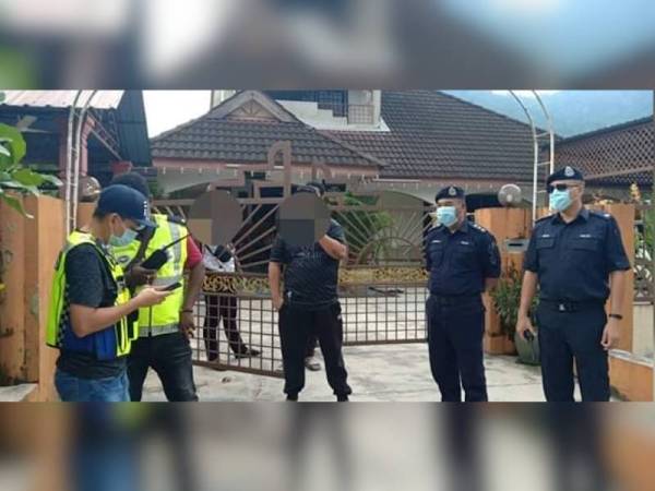 Osman (dua dari kanan) bersama pegawai dan anggota IPD Taiping membuat pemeriksaan di sebuah rumah di Taiping bagi memastikan orang ramai mematuhi SOP ditetapkan. - Foto Facebook Polis Daerah Taiping