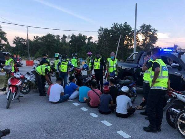 Anggota bertugas sedang melakukan pemeriksaan ke atas kesemua mat rempit yang ditahan sempena Op Samseng Jalanan, kelmarin. - Foto ihsan Facebook IPD Kemaman