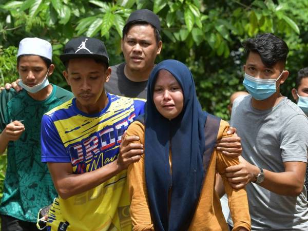 Anggota keluarga mangsa tidak dapat menahan sebak selepas penemuan mayat terakhir Khalif Naim Mohd, 16, di Sungai Terengganu, Kampung Kuala Telemong hari ini. - Foto Bernama