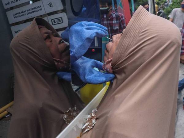 Seorang wanita mendapat ujian swab di laman Mobile Rapid Swab Test di Surabaya, Jawa Timur, Indonesia.