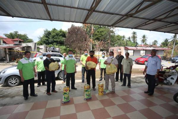 Guan Seng (tiga dari kanan) menyampaikan sumbangan kepada penduduk sekitar.