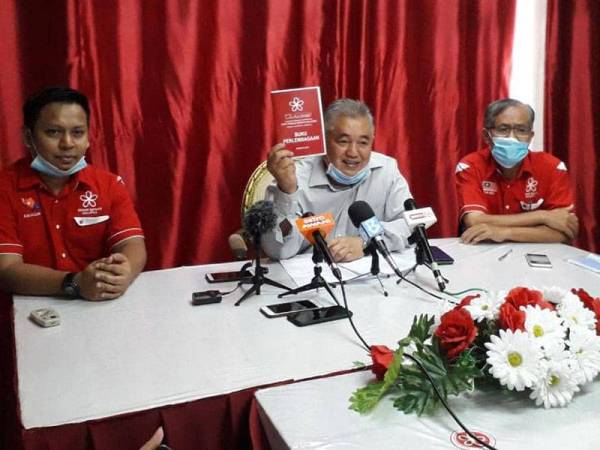 Md Nasir (tengah) menunjukkan buku Perlembagaan Bersatu selepas mengadakan sidang akhbar berkenaan pemecatan Tun Dr Mahathir dan empat pemimpin parti itu di Pejabat Bersatu Bahagian Johor Bahru, Larkin, Johor Bahru hari ini.