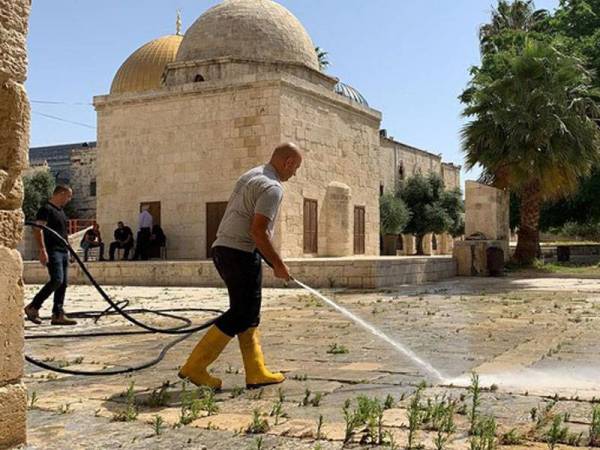 Semburan nyahjangkit dilakukan di kawasan pekarangan al-Aqsa menjelang pembukaan semula masjid itu ketika solat Subuh pada Ahad ini. - Foto Agensi