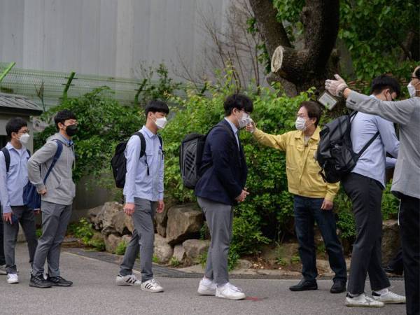 Hanya satu daripada tiga pelajar dibenarkan ke sekolah manakala rakan yang lain perlu menjalani sesi pembelajaran pada jarak jauh di bawah langkah lockdown baharu di Seoul itu. - FOTO: AFP