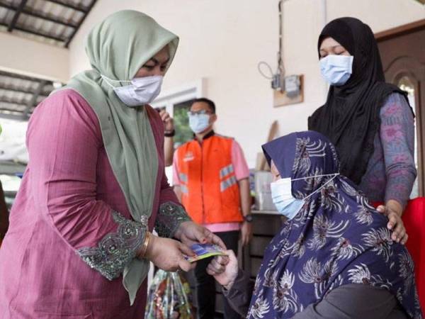 Shahaniza (kiri) menyampaikan sumbangan kerajaan Pahang kepada Sakiah iaitu ibu mangsa kemalangan maut yang dirempuh kereta pemandu mabuk di Jalan Pintasan Kuantan Selasa lalu.