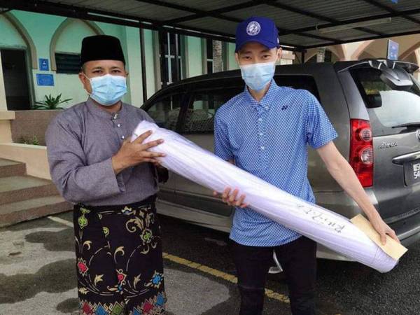 Chong Wei (kanan) memberi sumbangan kepada Masjid Al-Hidayah Kampung Sungai Penchala (MAHSP), Kuala Lumpur hari ini. - Foto Ihsan FB Masjid Al-Hidayah Kampung Sungai Penchala