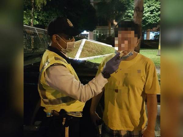 Anggota polis sedang menjalankan pemeriksaan ke atas pengguna jalan raya.