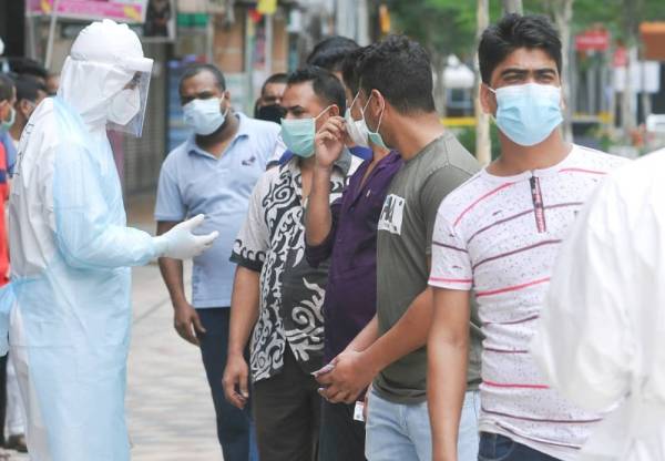 
Petugas kesihatan memberi penerangan kepada warga asing sebelum melakukan ujian saringan.