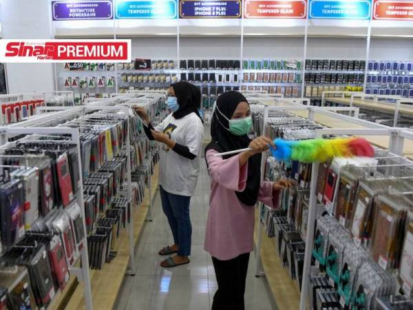 Pekerja sebuah kedai aksesori telefon bimbit melakukan persiapan untuk memulakan operasi perniagaan. -Foto Bernama