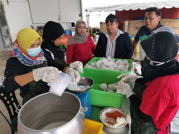 Ahmad Afandi (empat dari kiri) melihat pekerjanya membuat pembungkusan santan segar.