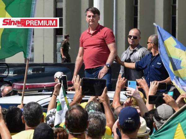 Bolsonaro (berdiri di kiri) menyertai protes menentang arahan duduk di rumah yang dikeluarkan gabenor negeri di Brazil.