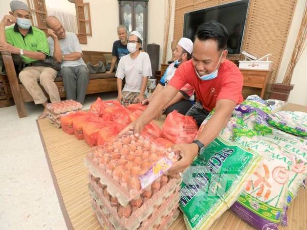 Wan Muhamad Hafizzul (dua dari kanan) pada program agihan bantuan keperluan harian kepada golongan mak nyah di Seri Teruntum.