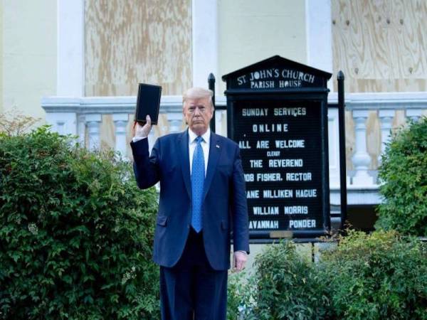 Trump memegang kitab Bible ketika mengunjungi sebuah gereja di Washington semalam. - Foto Agensi