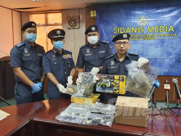 Johari menunjukkan kotak permainan yang dihantar bersama bungkusan ganja.