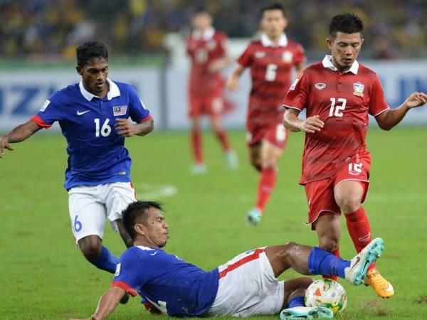 Shukor Adan mengasak pemain Thailand, Prakit Deeprom (kanan) semasa aksi final kedua Kejuaraan AFF Suzuki 2014 di Stadium Nasional Bukit Jalil Kuala Lumpur pada 20 Disember 2014.