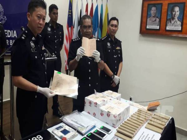 Mohd Padzli (tengah) dan Timbalannya, Superintendan Lim Jit Huey (kiri) menunjukkan salinan surat MC palsu yang dijual sindiket kepada pekerja sekitar Johor Bahru dan negara jiran pada sidang akhbar di IPD Johor Bahru Selatan, Larkin, Johor Bahru hari ini.