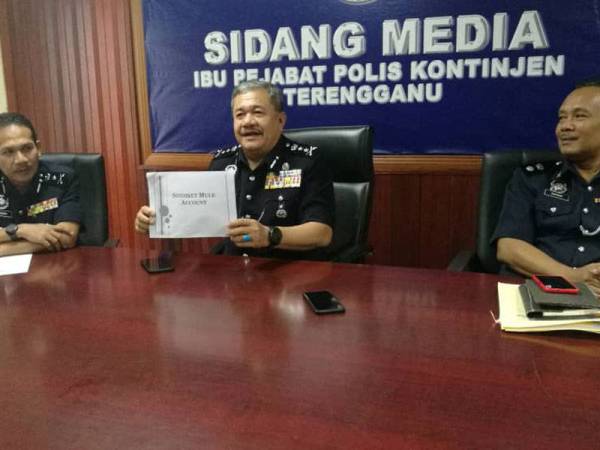 Roslee (tengah) menunjukkan lampiran laporan Operasi Khas 'Sindiket Mule Account' pada sidang media di IPK Terengganu, di sini hari ini. Hadir sama Timbalannya, Datuk Rohaimi Md Isa (kiri) dan Ketua Jabatan Siasatan Jenayah Komersial negeri, Superintendan M. Zambri Mahmud (kanan).