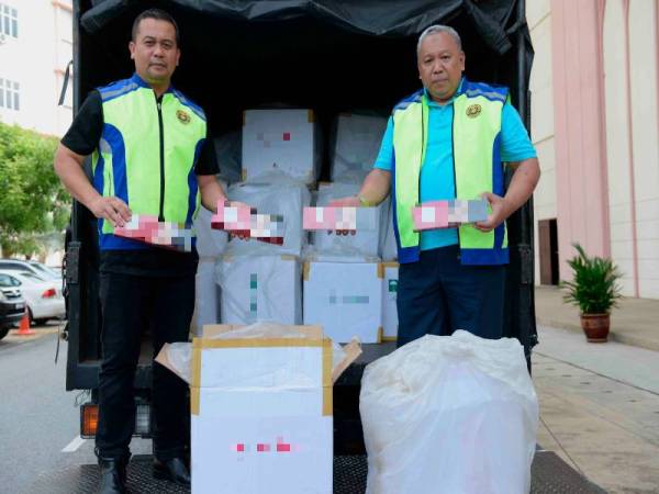 Abdul Latif (kanan) menunjukkan rokok yang dirampas di AKSEM Anak Bukit di sini hari ini. - Foto Bernama