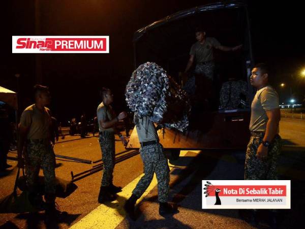 Anggota tentera mengemas peralatan yang digunakan semasa sekatan jalan raya pada hari terakhir Tempoh Perintah Kawalan Pergerakan Bersyarat (PKPB) dilaksanakan di Plaza Tol Bertam malam tadi. - Foto Bernama