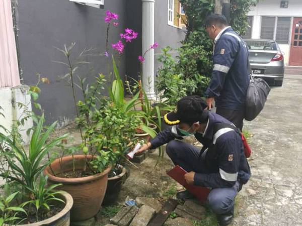 Dua kakitangan Jabatan Kesihatan sedang memeriksa takungan air yang boleh menyebabkan pembiakan nyamuk aedes di sebuah rumah di Bukit Besar di sini.