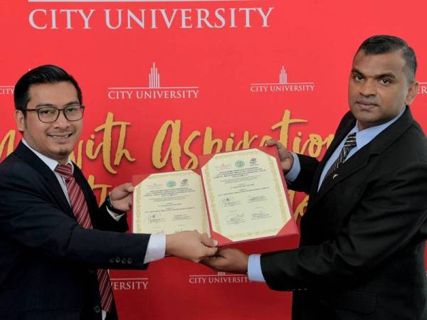 Dr Masri bertukar-tukar dokumen dengan B. Subramaniam (kanan) pada Majlis Menandatangani Memorandum Persefahaman (MOU) Biasiswa Pelajar India Johor antara City University Malaysia, Johor Bahru dengan Malaysian Indian Congress Youth Johor (MICJ) di kampus universiti berkenaan hari ini. - Foto Bernama