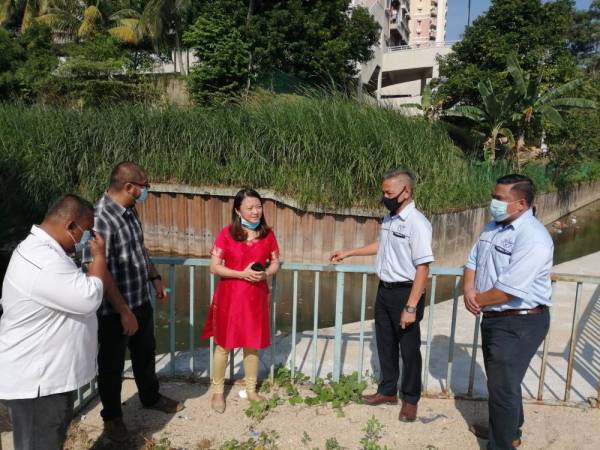 Hamnah (tengah) turun padang meninjau lokasi sungai yang akan dinaik taraf di bawah projek tebatan banjir. 