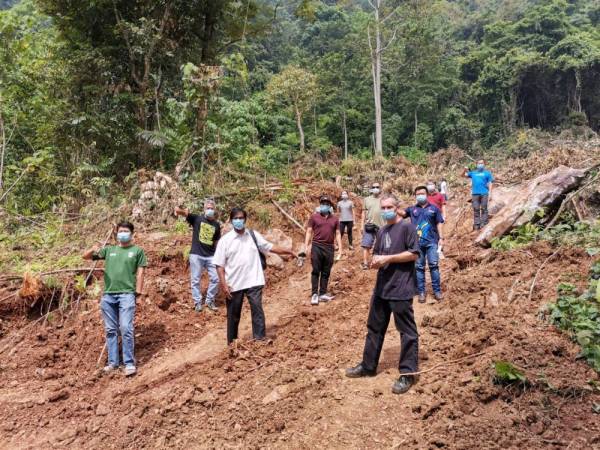 Penduduk bersama wakil badan bukan kerajaan (NGO) yang hadir menunjukkan kesan tanah rizab yang diteroka untuk pemasangan pagar. 