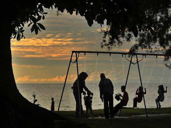 Kelihatan orang ramai bersama keluarga mengambil peluang beriadah serta menikmati pemandangan senja yang indah di sekitar Pantai Kampung Batu Manikar Labuan semalam. - Foto Bernama