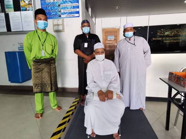 Razali (tengah) bersama pihak pengurusan masjid selepas menunaikan solat Jumaat di masjid itu hari ini.