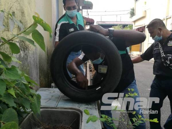 Jeyagopi (kiri) bersama pegawai Pejabat Kesihatan Daerah Kinta dan MBI melakukan pemeriksaan kawasan sekitar kawasan Kampung Kacang Putih di sini.