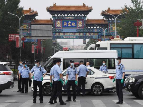 Pasukan polis berkawal di pintu masuk pasar Xinfadi di Beijing yang ditutup sejak semalam. - Foto AFP