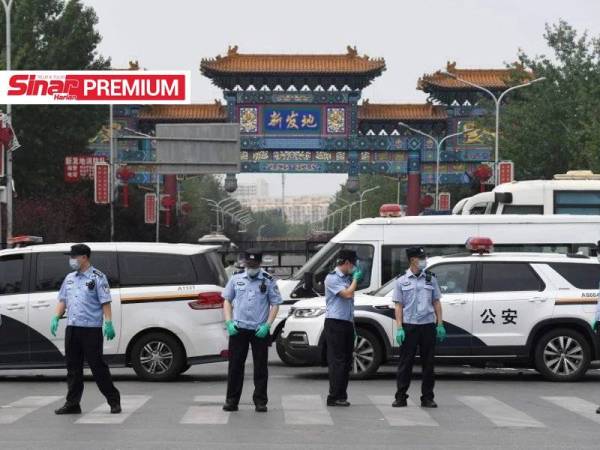 Polis mengawal pasar Xinfadi, Beijing pada 13 Jun lalu. - Foto AFP