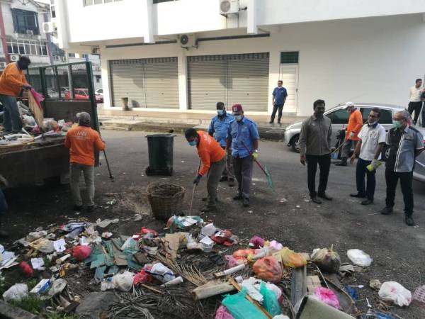 Sebahagian pekerja MBI membersihkan sampah haram di Taman Kin Mee, di sini hari ini.