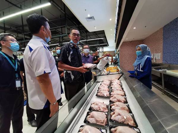 Rosol (dua dari kanan) meninjau harga ayam di sebuah pasar raya.