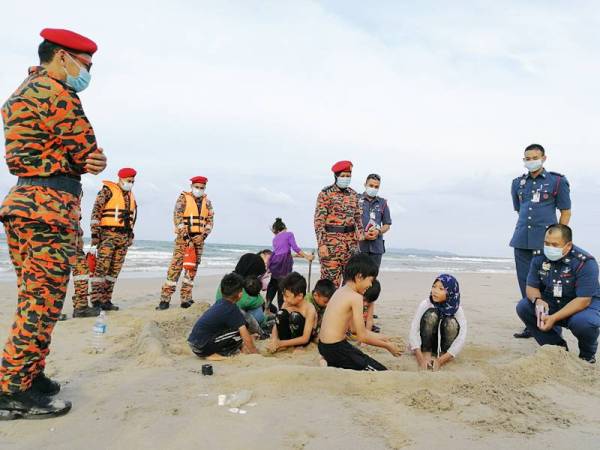 Mohd Khairiri (kanan) menyapa sekumpulan kanak-kanak yang bermain di Pantai Pandak.