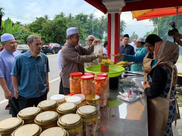 Izani meluangkan masa membeli jagung di gerai-gerai yang disediakan kerajaan negeri di kawasan tersebut.