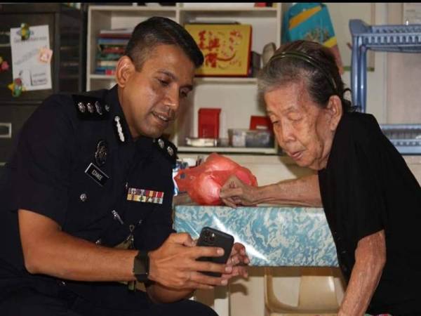 Nik Ezanee beramah mesra dengan seorang wanita warga emas. - Foto Ihsan FB Polis Daerah Petaling Jaya.