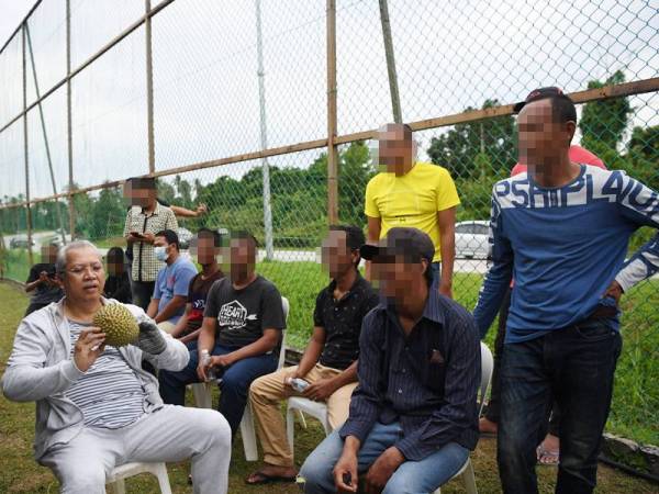 Tan Sri Annuar Musa (kiri) bersama-sama menikmati buah durian dengan golongan gelandangan yang menjalani kursus 'Latihan Pembangunan Sahsiah Diri' di Casa Villa dekat Kampung Sungai Soi, hari ini. - Foto Bernama.