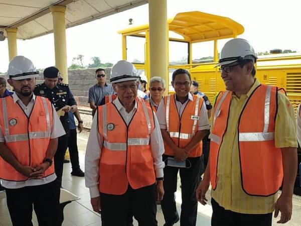 Mustapa Mohamed (tengah) melihat perkembangan Projek Landasan Berkembar Elektrik Gemas-Johor Bahru (PLBEGJB) di bandar Kulai, Johor hari ini.