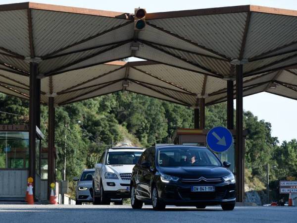 Kenderaan merentasi sempadan Perancis-Sepanyol di La Jonquera selepas sekatan ditarik balik bermula hari ini. - FOTO: AFP