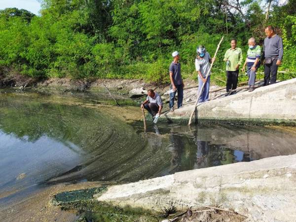 Penduduk menunjukkan air sungai Kuala Kerpan yang bertukar menjadi kehitaman.