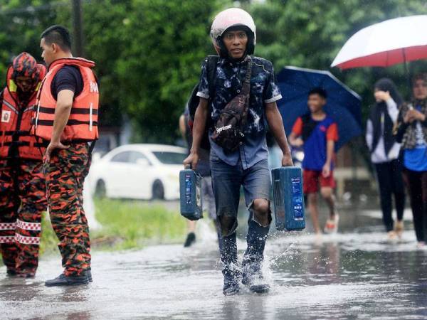 Banjir kilat melanda beberapa daerah di Johor sejak Sabtu lepas apabila beberapa kawasan rendah dinaiki air berikutan hujan lebat melebihi kadar biasa ditambah fenomena air pasang. - Foto Bernama