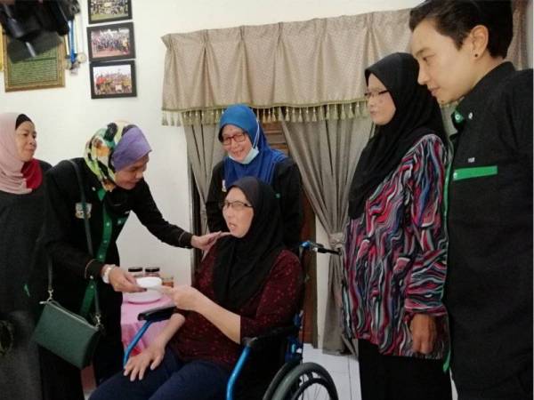 Normala menyerahkan sumbangan terkumpul Persatuan Pemain Bola Sepak Wanita Malaysia dan PAFA kepada Rozanawati dalam kunjungannya hari ini.