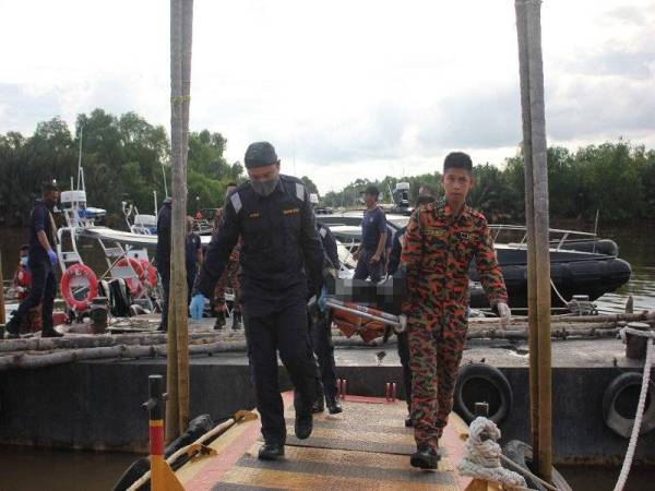 Anggota APMM dan bomba mengusung mayat kru bot di Jeti Maritim Batu Pahat selepas ditemukan di perairan Tanjong Laboh petang tadi.