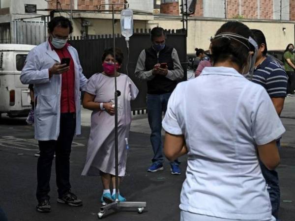 Beberapa pesakit dan kakitangan perubatan berkumpul di luar sebuah hospital berikutan gempa bumi kuat di bandar raya Mexico pada 23 Jun lalu. - Foto AFP