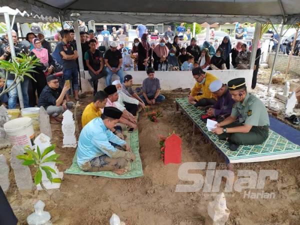 Ahli keluarga dan rakan taulan ketika bacaan talkin selepas pengebumian jenazah Allahyarham di Tanah Perkuburan Islam Klebang Besar di sini tadi.