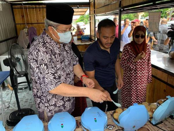 Annuar melihat proses menyediakan kuih akok yang diusahakan Muhammad Shamil di Peringat.