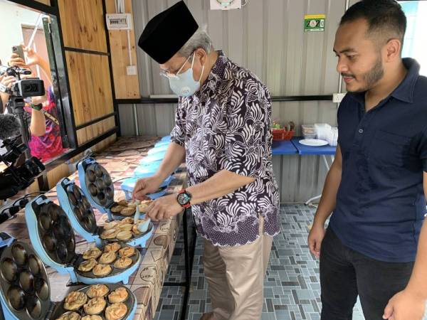 Annuar turut mencuba menyediakan akok di gerai Akok Pok Long di Peringat, Kelantan hari ini.